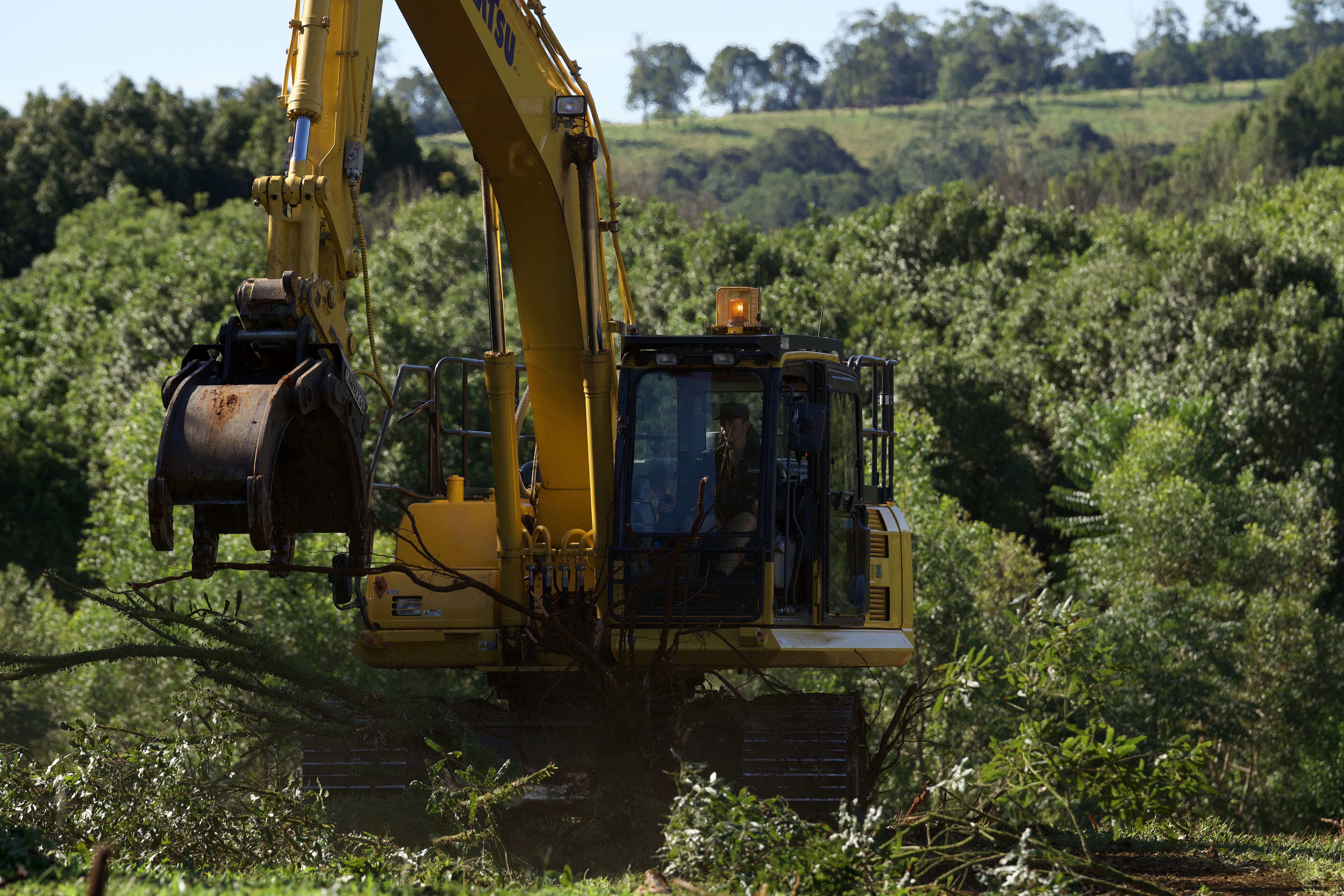 Excavator on site with green hills